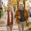 Twee volwassenen wandelen samen buiten op een rustige ochtend.